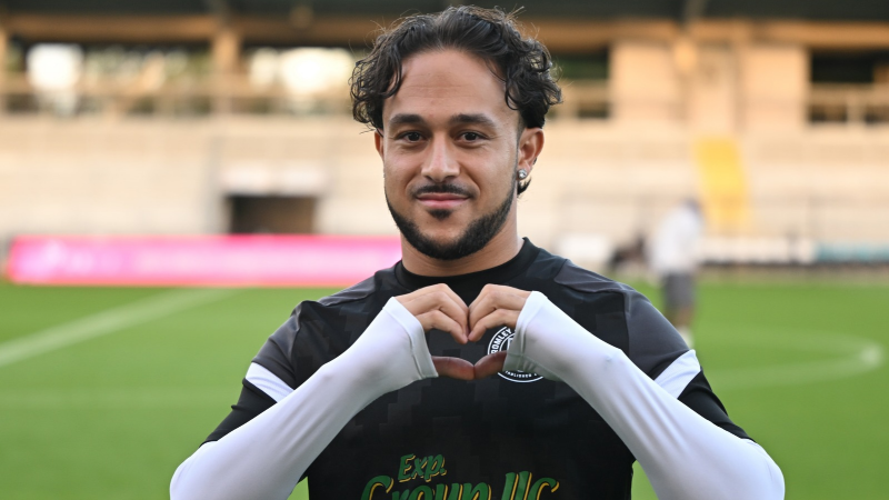Photo of Jodi Jones, striker for Bromley FC making heart sign with hands.