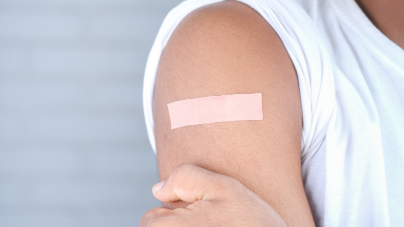 Photo of a person's arm with a plaster attached after receiving a vaccination jab.