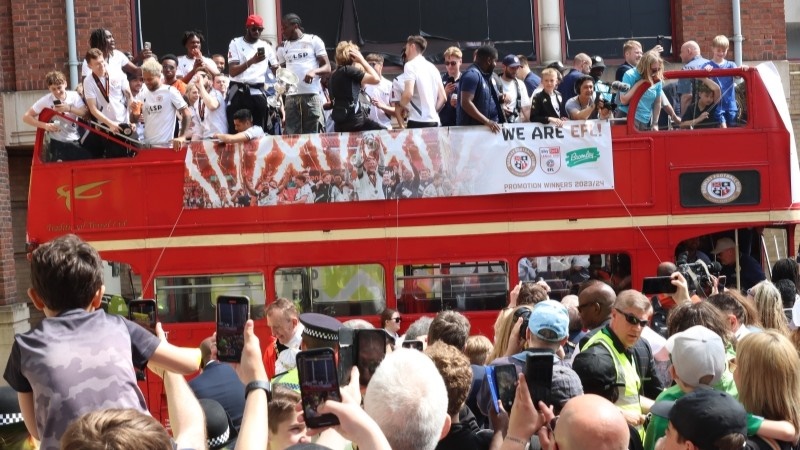 Bromley FC players celebrating on open top bus in Bromley town centre.