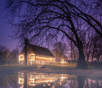 Evening setting at Brown &amp; Green Life. Illuminated building and lake.