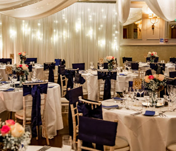 The Bulls Head ceremony room with voile lit curtain and decorated tables.