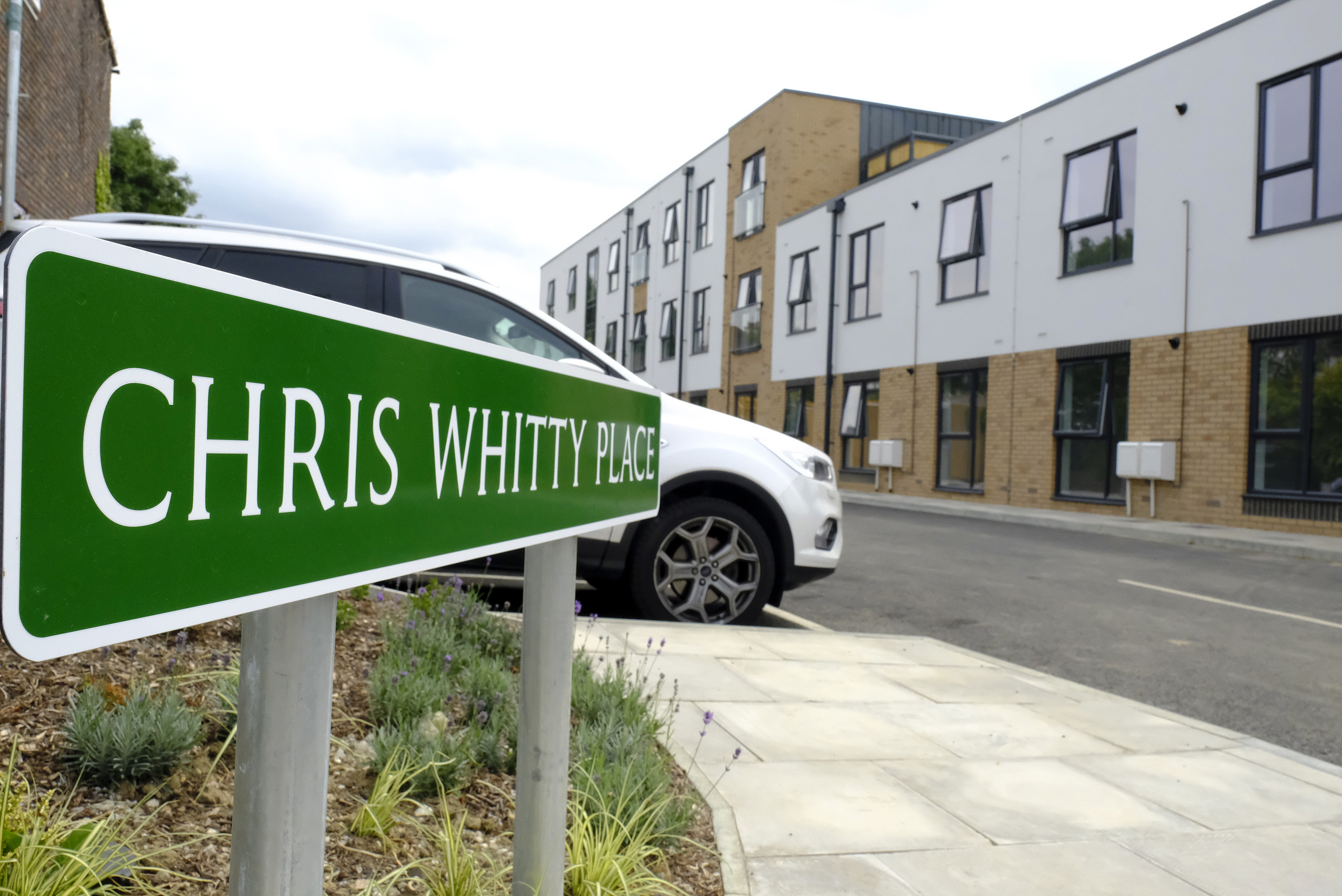 Chris Whitty Place road sign in front of the new building.