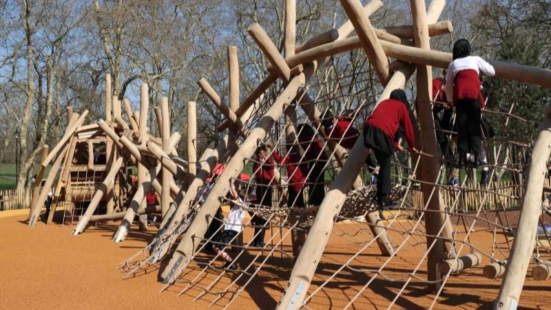 School class playing on the new dinosaur climbing frame in Crystal Palace Park.