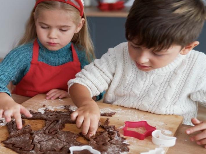 Two children making Christmas cookies.