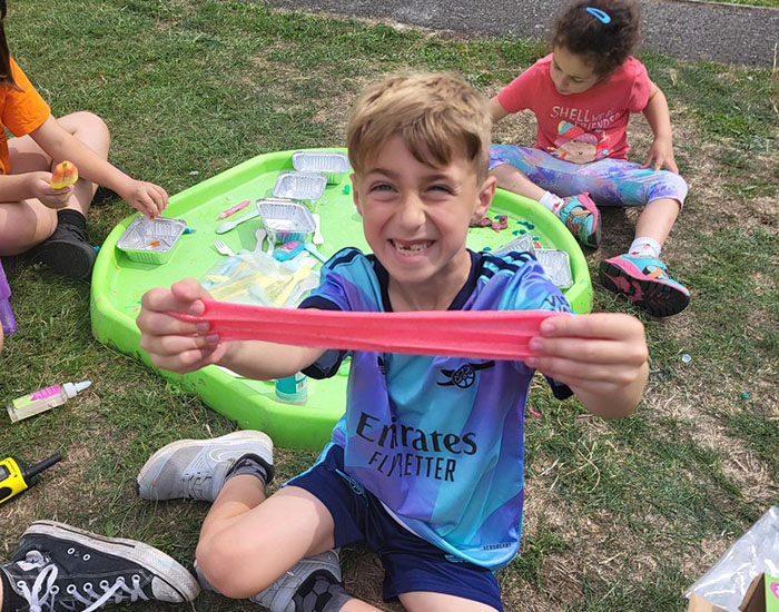 CASPA - Link Youth Acitvity Centre: Photo of three children sat outside playing with arts and crafts materials and a play set.
