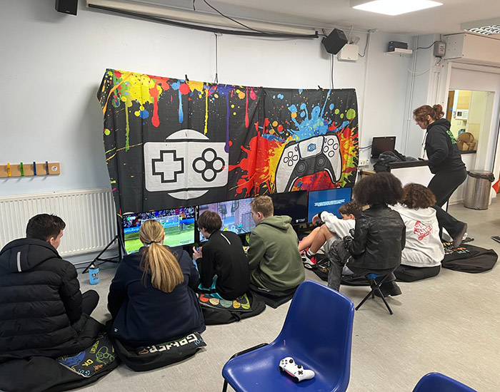 CASPA Teen Hangout - Turpington Activity Centre: Photo of 8 young people sat together inside playing video games.