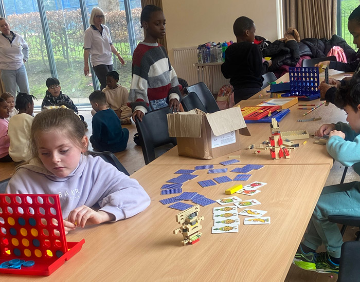 Clarice Fitness - St Hugh's Community Centre: Photo of a large group of children in an activity hall playing a series of board and card games together.