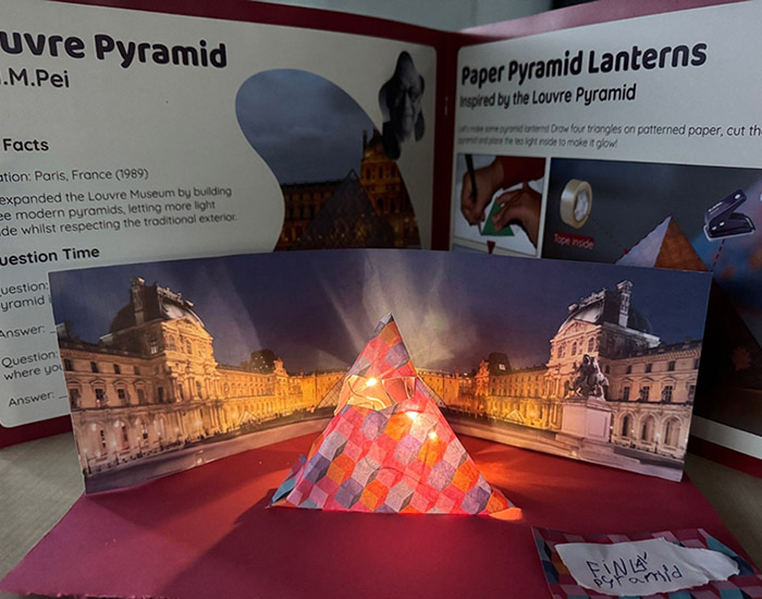 Idea Design Hub - Bromley Quaker Centre: Photo of a homemade art display of a paper pyramid lantern in reference to the Louvre pyramid building.