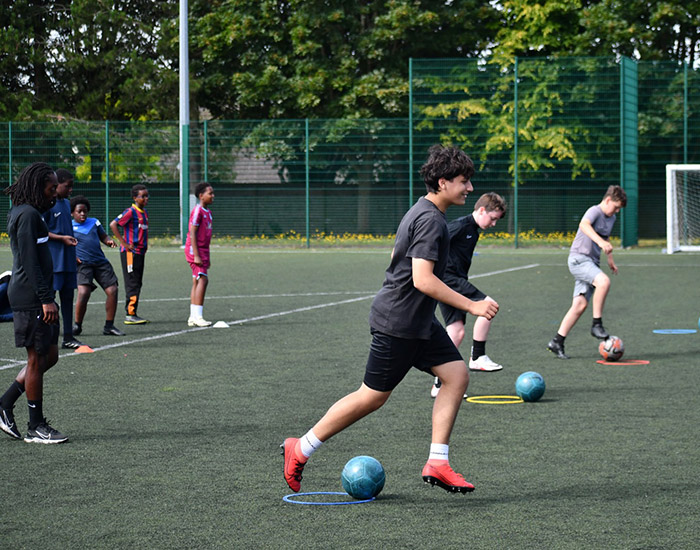 Kinetic Foundation Football - Harris Academy Orpington: Photo of a group of young people taking part in a football session on an astro turf surface.