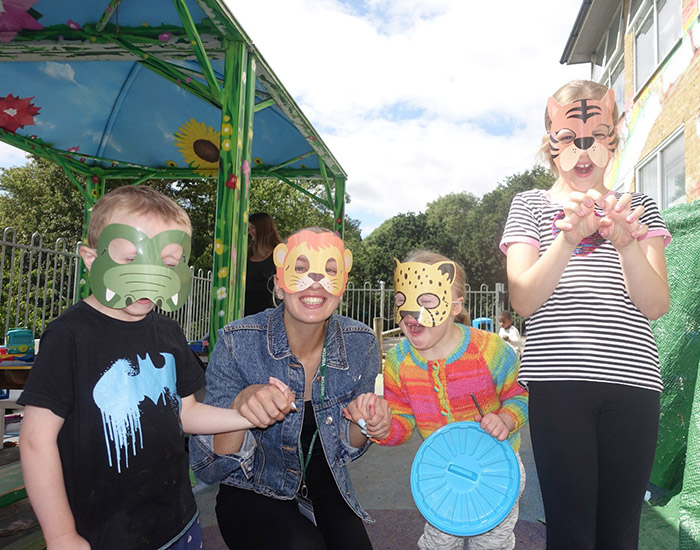 Zap Kids Summer Sessions - Midfield Primary: Photo of 3 children and an instructor outside together while wearing homemade animal masks.
