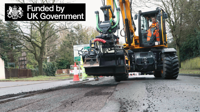 Image shows road maintenance vehicle and Funded by UK Government logo underneath.