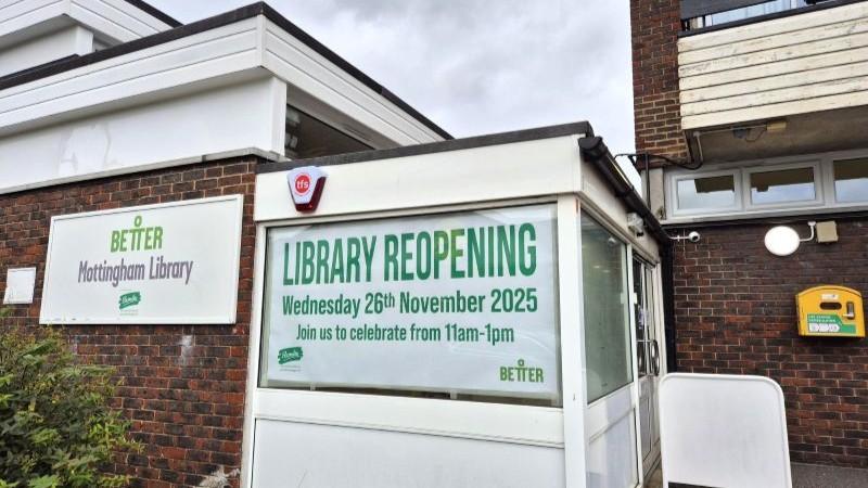 Mottingham Library with sign about library reopening in window.