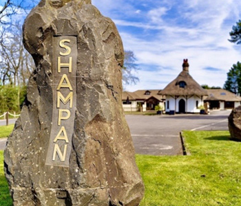 Small thatched cottage with Shampan sign on a rock.
