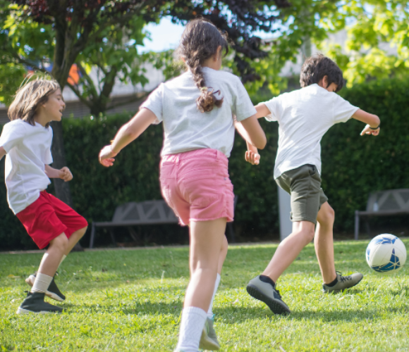 Three children playing football.