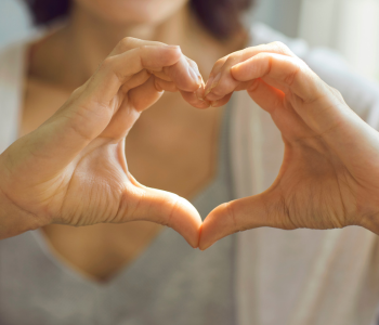 Photo of person making a heart-sign with their hands.