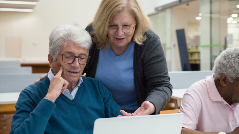Adult learners looking using a laptop.