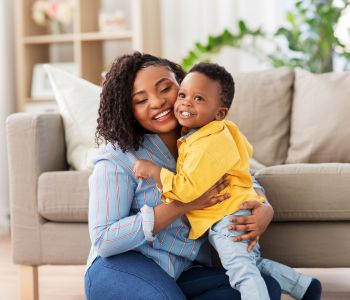 Single foster carer sharing a hug with a foster baby.